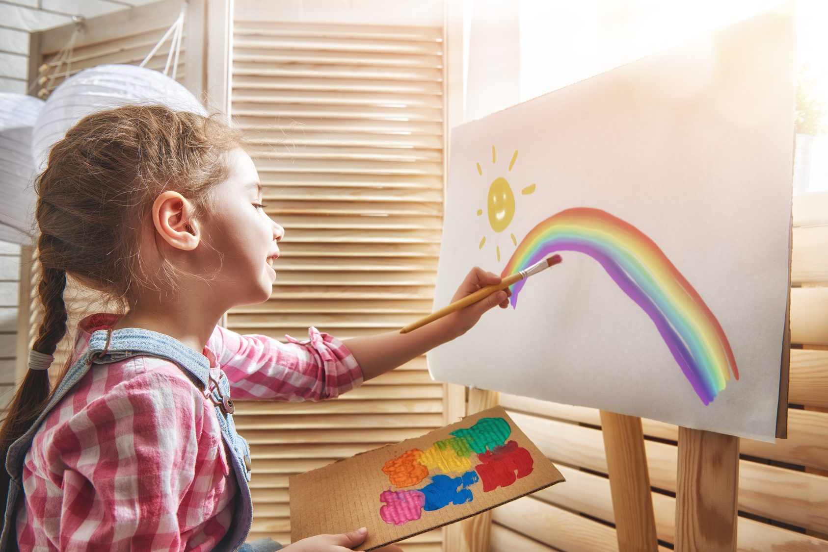 Маленькая девочка рисует красками